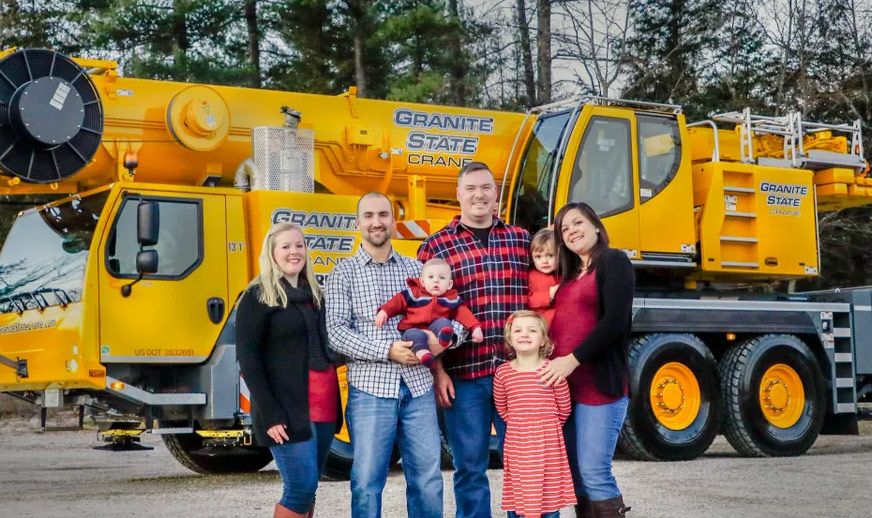 The Granite State Crane family in front of one of their cranes